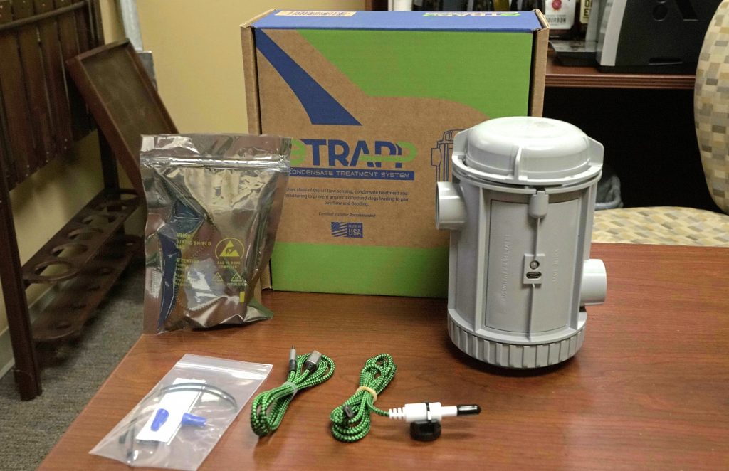 an etrapp unit, accessories, and installation kit are displayed with the box on a desk